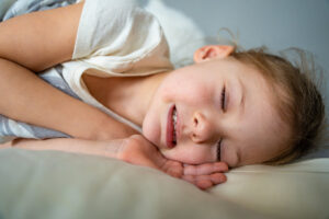 Cute little girl sleeping and grinding teeth in dreams, clenched teeth with tiredness and stress. High quality photo