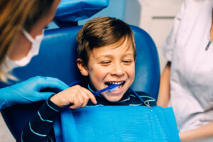 Doctor dentist teaching a child to brush teeth.