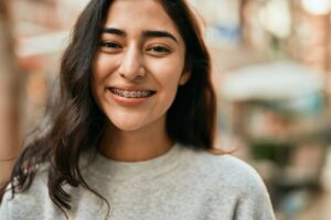 Young woman smiling confidently in New York City, representing braces treatment at SmileWorks NYC