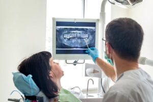 Dentist showing an adult patient their dental X-ray on a monitor